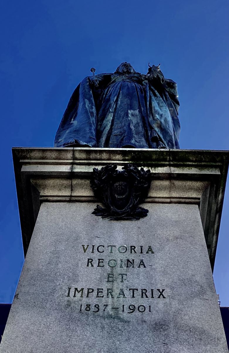 photo looking up at a statue of queen victoria